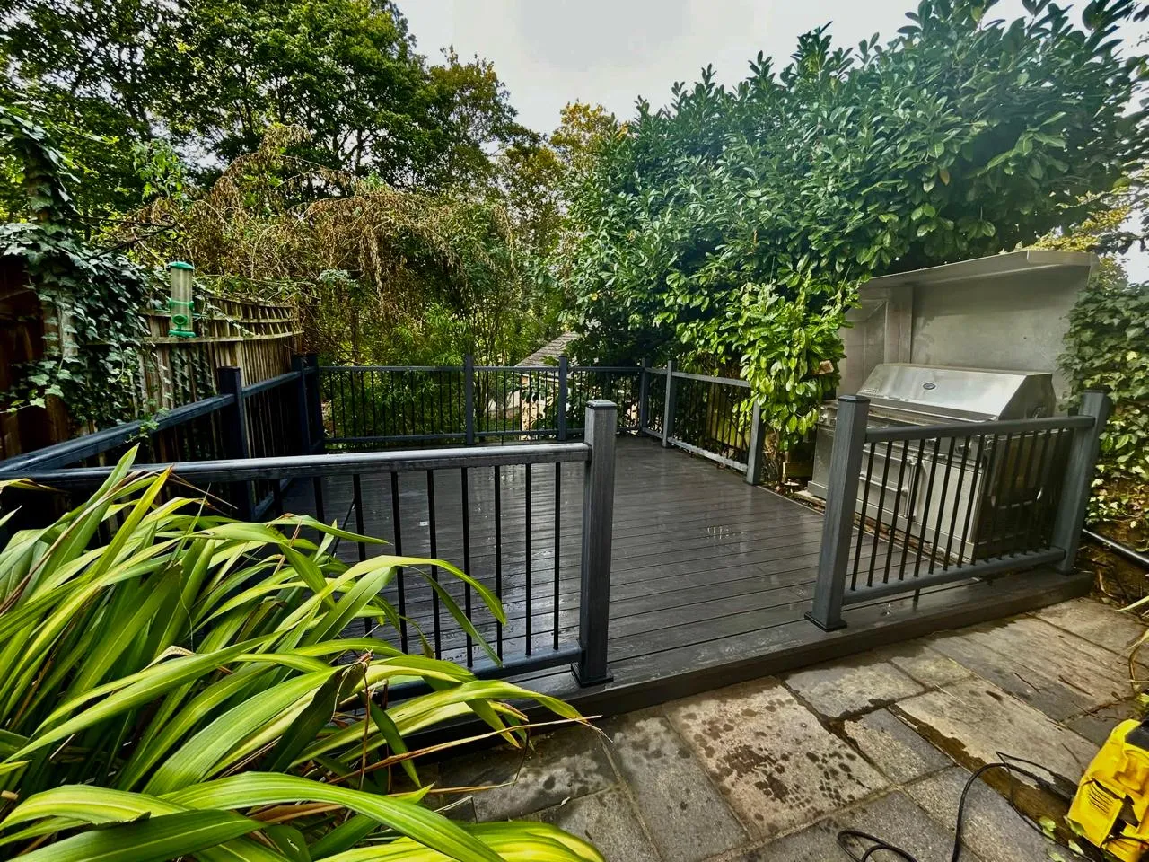 A deck with a grill in the middle of it.