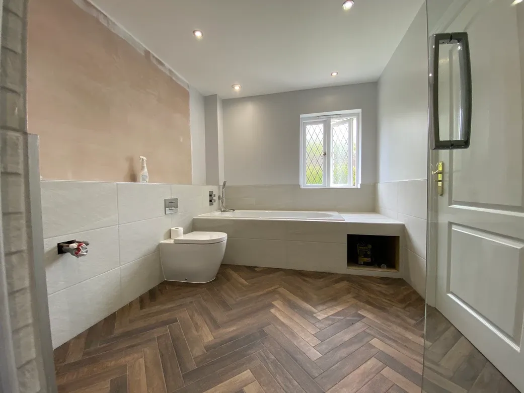 A bathroom with a toilet, sink, and tub.